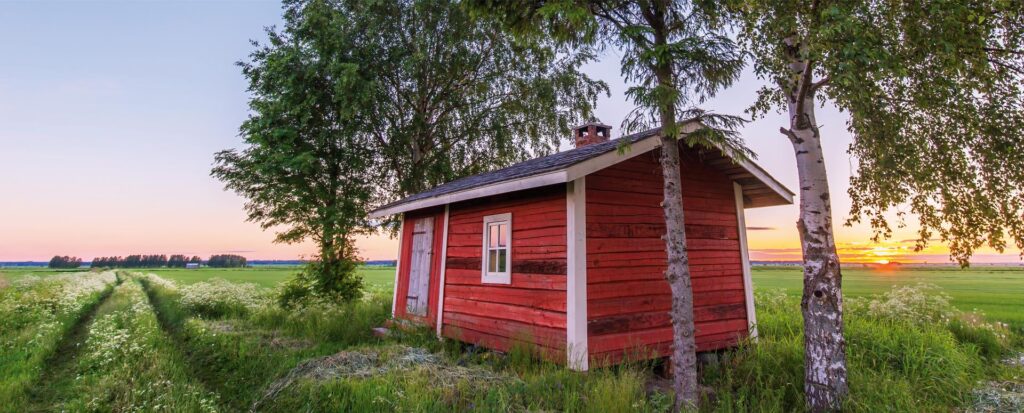 Punainen mökki, pellon laidalla.